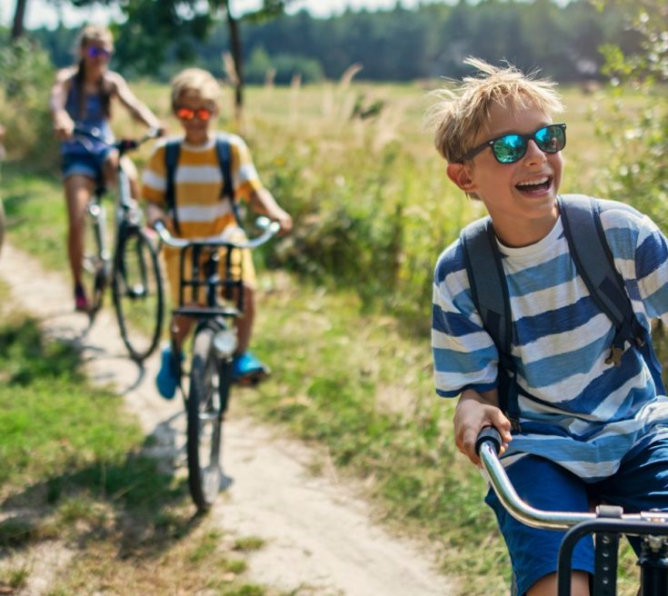 4 people cycling through a field