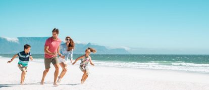 Happy family running on a beach